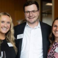 One man and two women standing together and smiling for photo